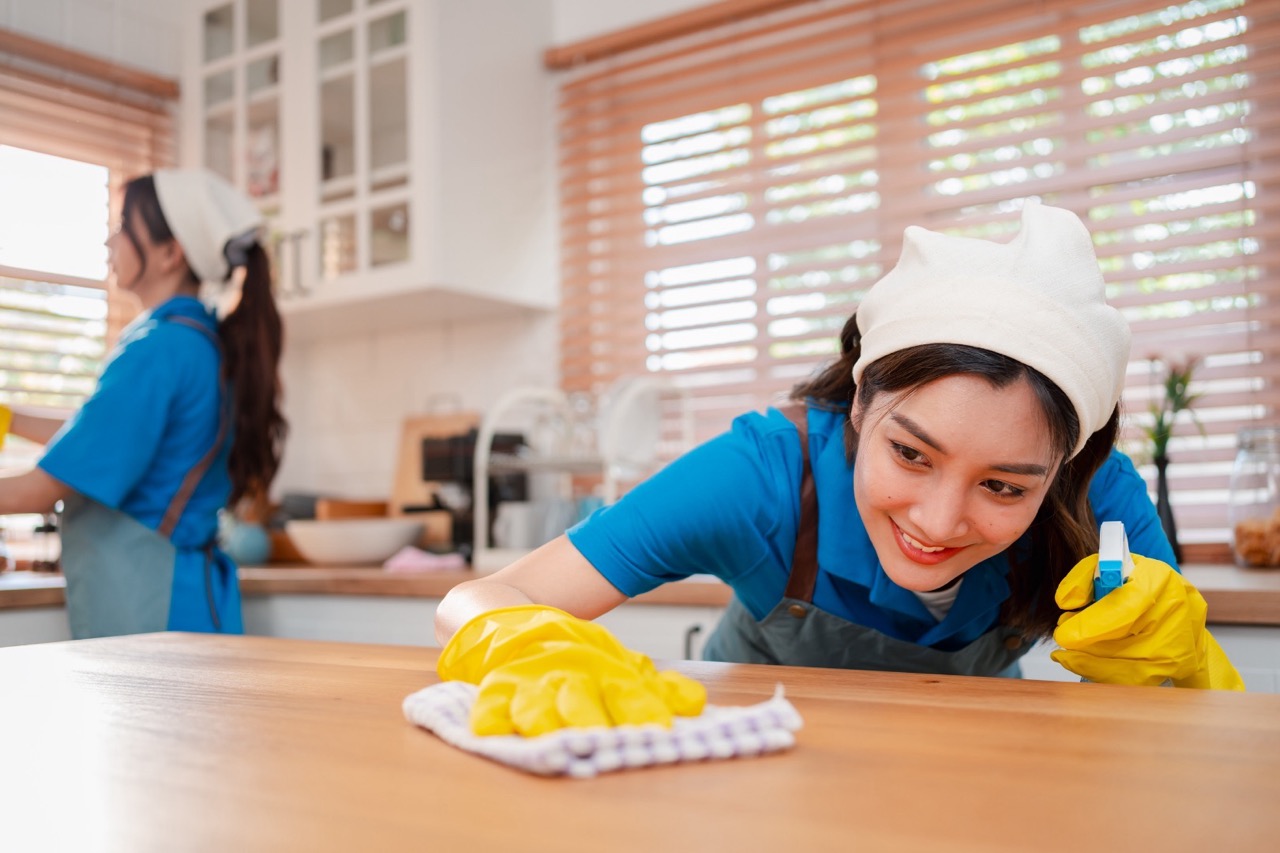 Professional cleaning team scrubbing kitchen counters and surfaces